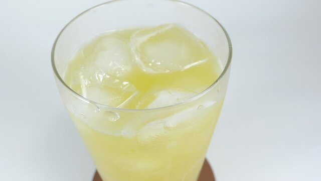 氷を入れたグラスに注ぐオレンジジュース
