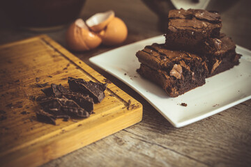 Close up of baked chocolate brownies with ingreditents in the background.