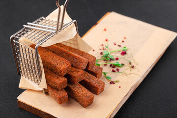 Hot deep-fried dark bread sticks, scattered from grid