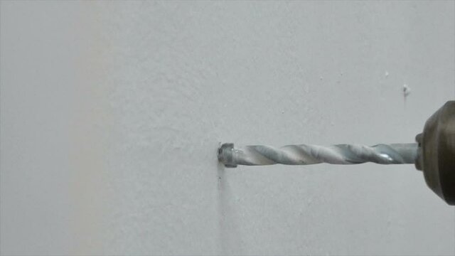 Close up shot electric drill is drilling a concrete wall selective focus shallow depth of field 