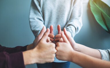 People making thumb up hands sign in circle