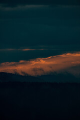 sunrays shining through clouds during sunset