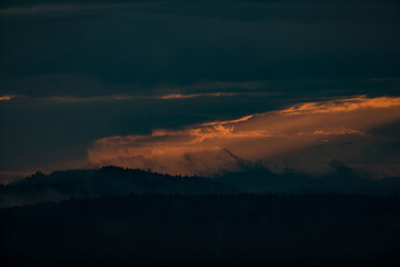 sunrays shining through clouds during sunset