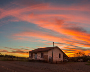 old abandoned house farm in a colourful sunset sky