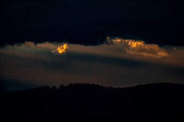 sunrays shining through clouds during sunset