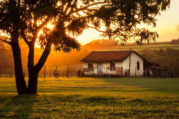 orange sunset on the farm with old house