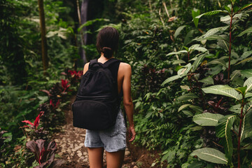 Traveler woman with backpack walking on path in jungle tropical deep forest, Tourism beautiful destination Asia