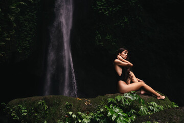 young woman backpacker looking at the waterfall in jungles. Ecotourism concept image travel girl