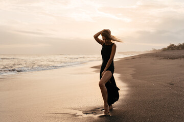 woman on beach is enjoying serene ocean nature during travel holidays vacation outdoors sunset time