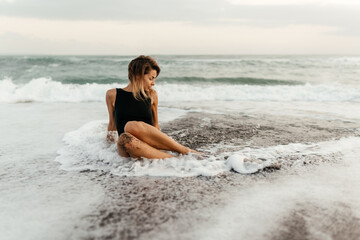 Fototapeta na wymiar woman on beach is enjoying serene ocean nature during travel holidays vacation outdoors sunset time