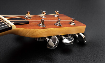 Head of acoustic guitar  on black. Macro photo.