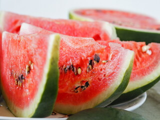 Sliced pieces of red watermelon in the foreground. Autumn food background.