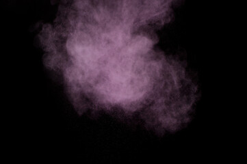 Purple powder explosion on black background. Colored powder cloud. Colorful dust explode. Paint Holi.