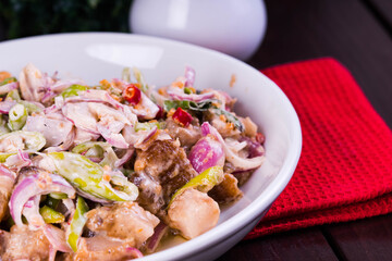 crispy pork belly in savory mayonnaise with fresh red onions and green chilli
