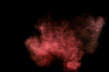 Red and pink powder explosion on black background. Colored powder cloud. Colorful dust explode. Paint Holi.