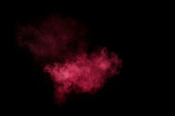 Red and pink powder explosion on black background. Colored powder cloud. Colorful dust explode. Paint Holi.