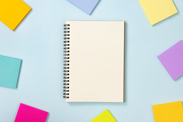 Spiral Notebook or Spring Notebook in Unlined Type and Multi Color Sticky Note on Blue Pastel Minimalist Background. Spiral Notebook Mockup on Center Frame