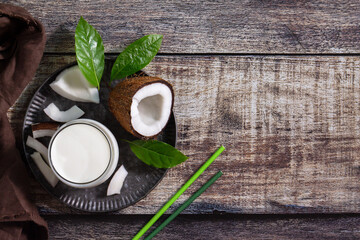 Diet and health nutrition concept. Vegan alternative nut milk from coconut on a kitchen table. Top view flat lay background. Copy space.