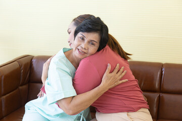 The ill Asian mother in the hospital was hugging her daughter with joy.