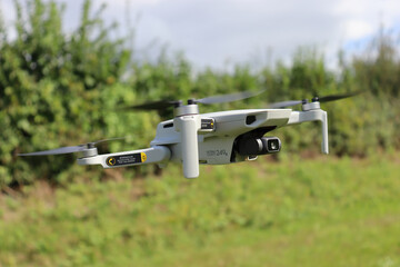 DJi Drone flying over the green field