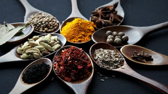 Colourful various herbs and spices for cooking on dark background.