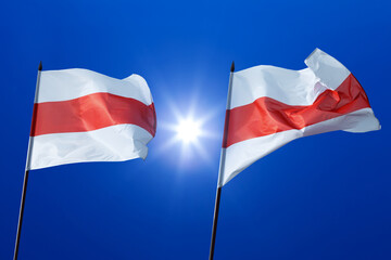 Historical flags of Belarus Republic above blue sky and sun