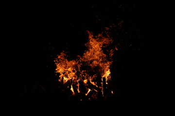 Fototapeta na wymiar the flame of a burning campfire on a black background