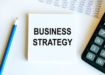 Wooden picture frame with inscription 'business strategy' on beautiful background from dollar bills...