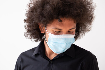 Latin american man wearing a medical mask looking down close-up 