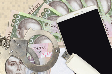 500 Ukrainian hryvnias bills and smartphone with police handcuffs. Concept of hackers phishing...