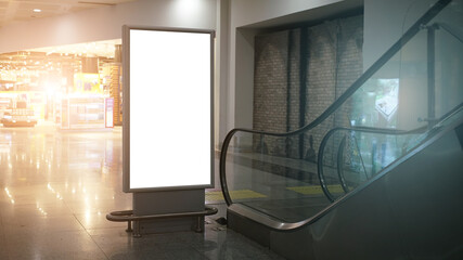 vertical advertise lcd lightbox with white mockup space in airport or mall building near moving...