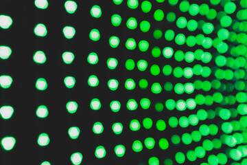 Abstract blurred green bokeh on black background. Green light from many bulbs at the festival.