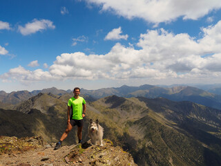 young man hiking in the mountains with his dog