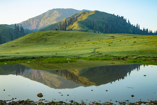 lush green landscape with small lake and mountains - mountain reflection on the water - siri paye Medows clear sky