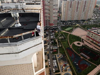 Beautiful girl on the roof of a high-rise skyscraper