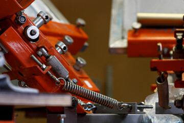 Print screening apparatus. serigraphy production. printing images on t-shirts in a design studio.