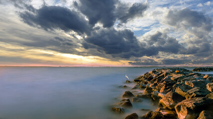 Stunning Long Exposure of the Chesapeake Bay at sunset with a Great Egret standing at the End of a Rock Jetty