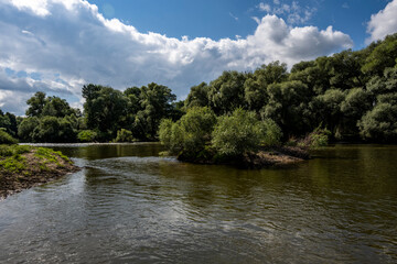 ruins of an old manor house among green trees against a blue sky