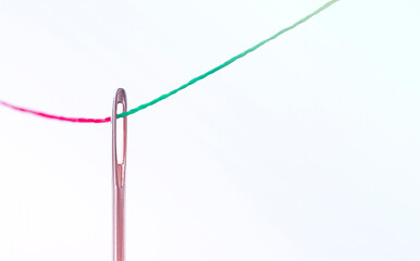 a red thread passes through the needle, a green one comes out. business concept