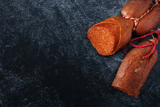 Sausages made in traditional majorcan style &ldquo;sobrasada&rdquo; close-up top view details with copy-space on dark background.