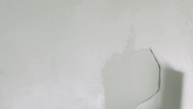 Slow motion handheld closeup worker applying decorative concrete plaster on the wall