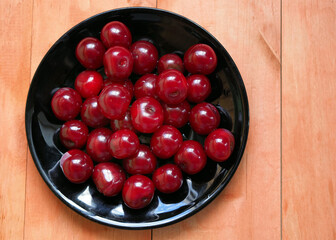 ripe cherries on a black plate