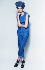 fashionable woman in denim jumpsuit and hat