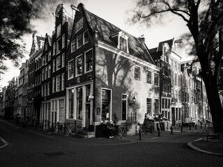 Fototapeta premium Amsterdam, Holland, the Netherlands - July 6 2020: capture of the typical Amsterdam scenery in black and white with canal, canalo house, clouds and the iconic buildings of the city