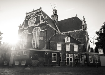 Fototapeta premium Amsterdam, Holland, the Netherlands - July 6 2020: capture of the typical Amsterdam scenery in black and white with canal, canalo house, clouds and the iconic buildings of the city