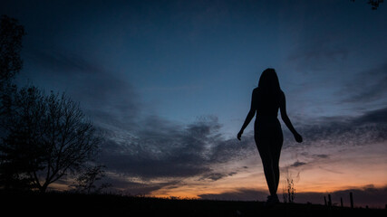Contraluz de una chica en el atardecer