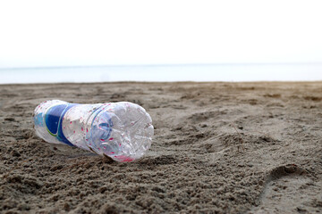 Plastic bottle not decomposed on sand beach background . Nature and environment concept.