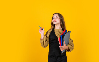 after lesson. happy kid model holding school folder. making notes. teen girl ready to work. writing...