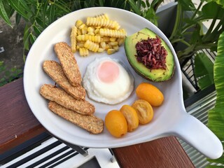Breakfast set include Berry rice avocado, fried egg, soy tempeh and tiny orange