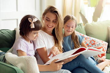 Portrait of happy family, mother reading a book to their children